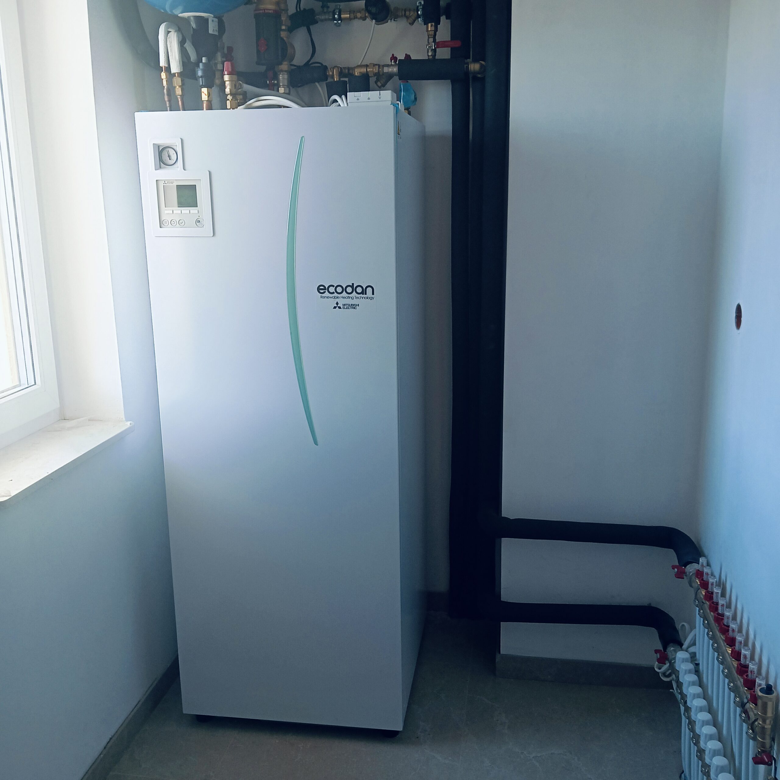 Jednostka wewnętrzna pompy ciepła Mitsubishi Electric Ecodan z podłączeniami instalacji — realizacja Ekoinstal